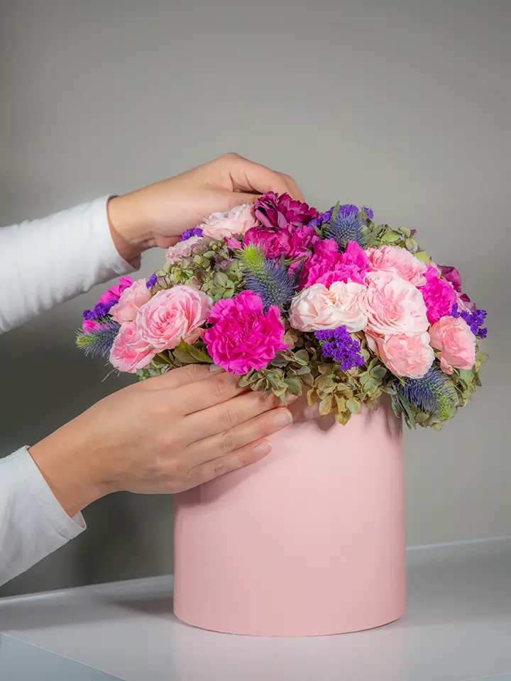 Flower box rosa di fiori rosa fuxia viola in mano
